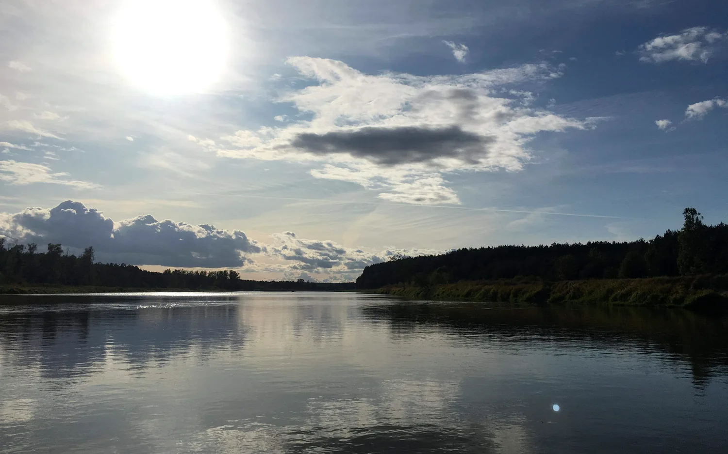 Spokojna tafla jeziora i szeroki mazurski krajobraz